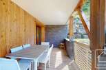 This stunning property boasts a spacious balcony with a wooden deck, perfect for outdoor dining.