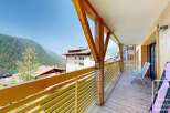 This stunning property boasts a spacious balcony with breathtaking mountain views, perfect for relaxing and enjoying the fresh alpine air.