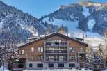 Luxury mountain lodge nestled in a snow-covered landscape, offering stunning views and ski-in/ski-out access.