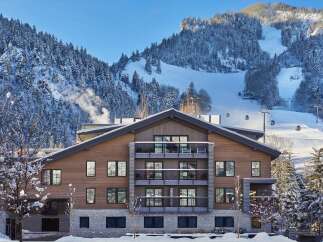 Luxury mountain lodge nestled in a snow-covered landscape, offering stunning views and ski-in/ski-out access.
