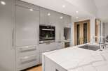Modern kitchen design with sleek gray cabinetry and a stunning white marble countertop.
