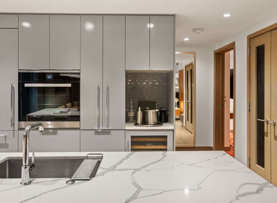 This modern kitchen boasts sleek, gray cabinetry and a stunning marble countertop, creating a sophisticated and functional space.