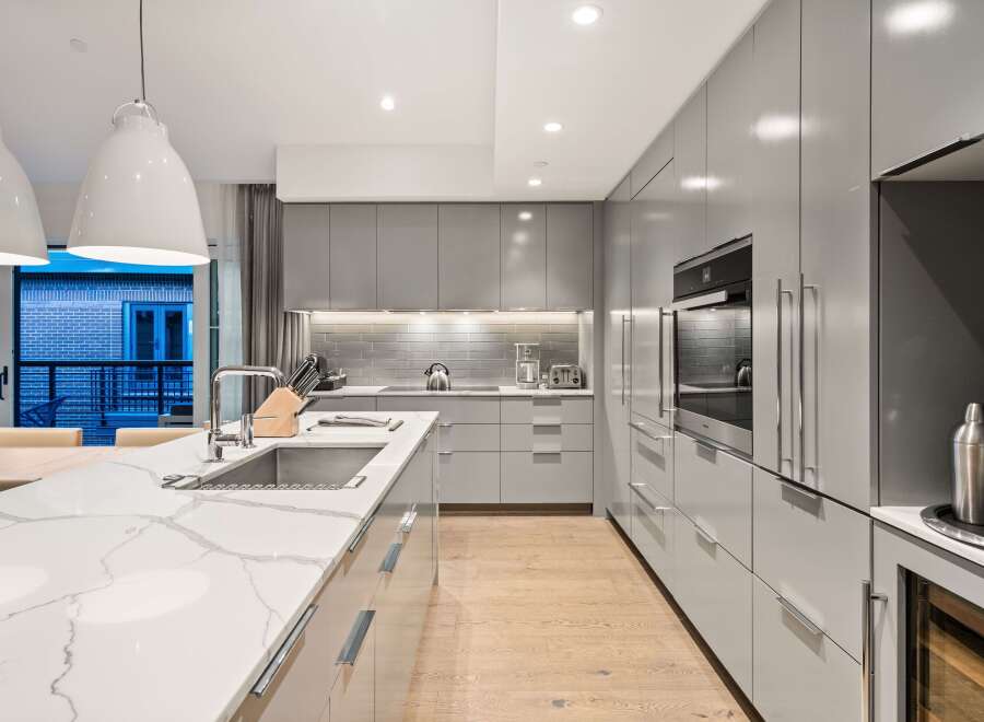 Modern kitchen design with sleek gray cabinetry and a stunning marble countertop.