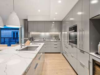 Modern kitchen design with sleek gray cabinetry and a stunning marble countertop.