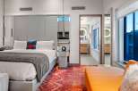 Experience luxury in this stunning hotel room, featuring a plush king-size bed and a vibrant, patterned rug.