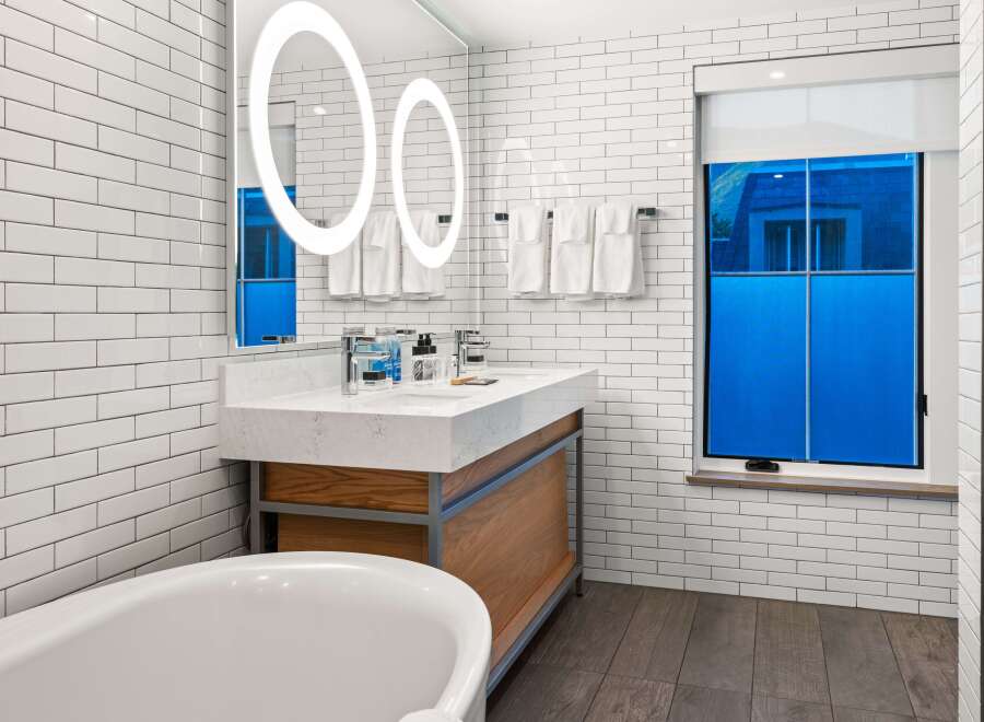 Step into a luxurious bathroom featuring a modern design with sleek white subway tiles.