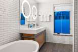 Step into a luxurious bathroom featuring a modern design with sleek white subway tiles.