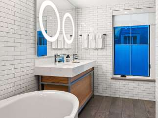 Step into a luxurious bathroom featuring a modern design with sleek white subway tiles.