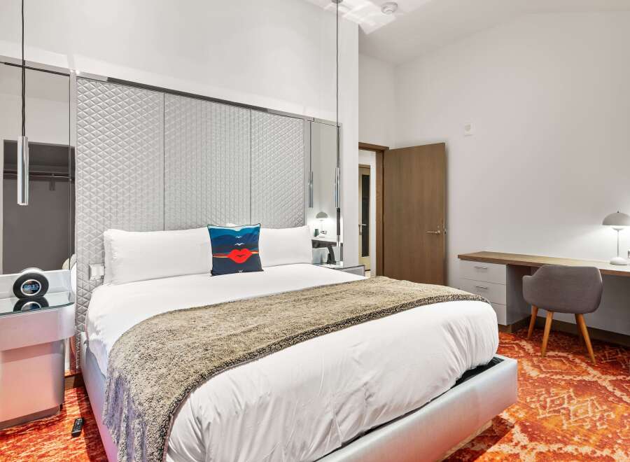 Experience luxury in this stunning bedroom featuring a plush king-sized bed with a stylish throw blanket.