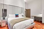 Experience luxury in this stunning bedroom featuring a plush king-sized bed with a stylish throw blanket.