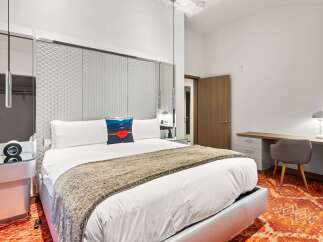 Experience luxury in this stunning bedroom featuring a plush king-sized bed with a stylish throw blanket.