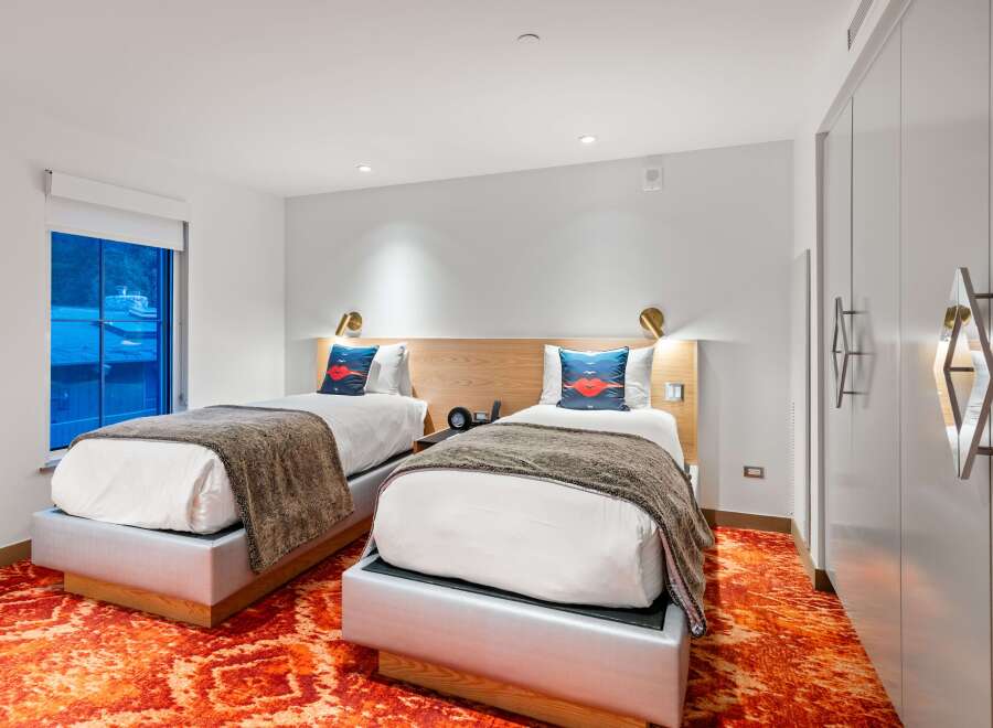 Experience modern comfort in this stylish hotel room featuring two cozy beds.
