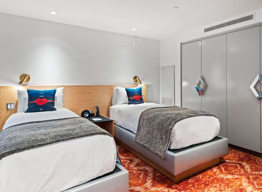Discover a stylish and modern hotel room featuring two comfortable beds, perfect for a relaxing stay.