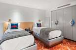 Discover a stylish and modern hotel room featuring two comfortable beds, perfect for a relaxing stay.