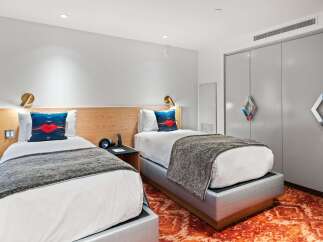 Discover a stylish and modern hotel room featuring two comfortable beds, perfect for a relaxing stay.