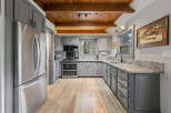 This charming kitchen boasts a rustic-chic design with knotty pine ceilings and exposed beams.