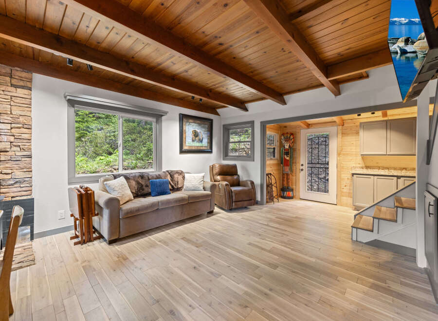 This stunning cabin boasts a spacious living area with hardwood floors, a cozy wood-burning fireplace, and large windows offering breathtaking views.