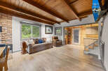 This stunning cabin boasts a spacious living area with hardwood floors, a cozy wood-burning fireplace, and large windows offering breathtaking views.