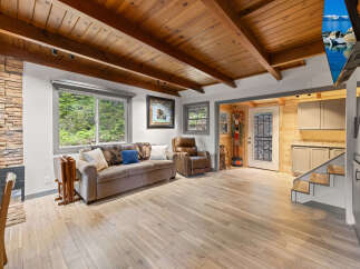 This stunning cabin boasts a spacious living area with hardwood floors, a cozy wood-burning fireplace, and large windows offering breathtaking views.