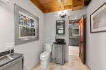 This charming bathroom boasts a modern design with a sleek, dark sink and gray vanity.