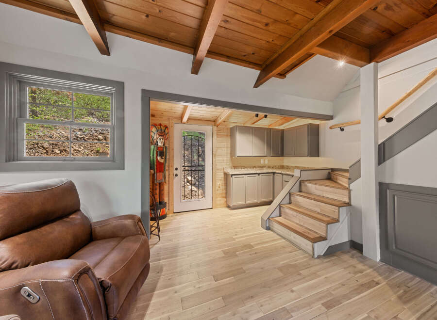 This stunning property boasts a spacious open-plan living area with hardwood floors and a cozy leather recliner.
