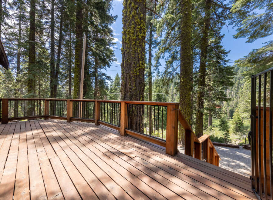 This stunning property boasts a spacious deck overlooking a breathtaking forest landscape.