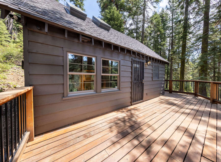 This charming cabin boasts a spacious deck perfect for enjoying the surrounding forest views.
