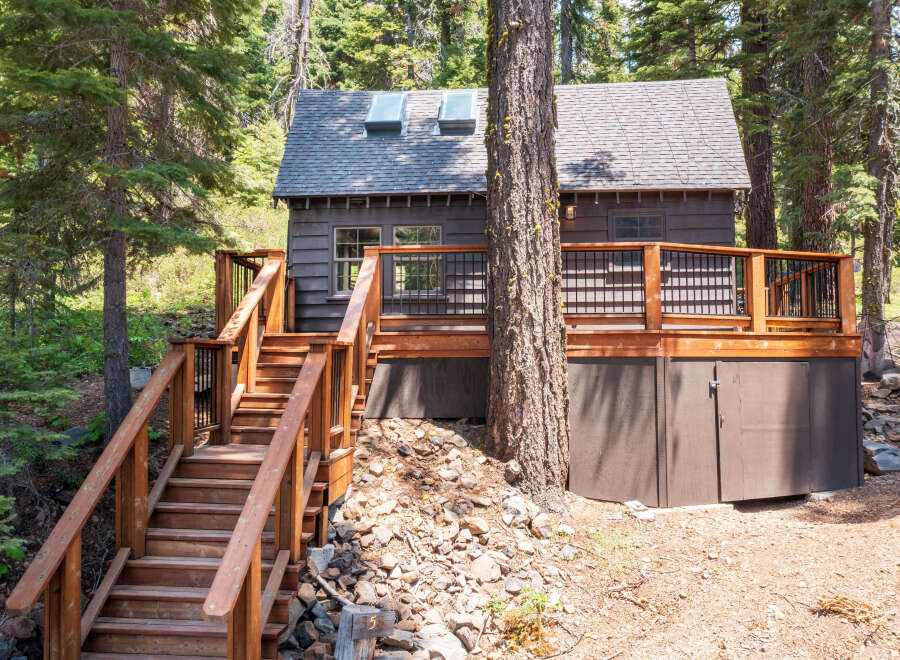 This charming cabin nestled in the woods offers a peaceful retreat.