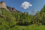 Mountaintop retreat with pond and lush greenery.
