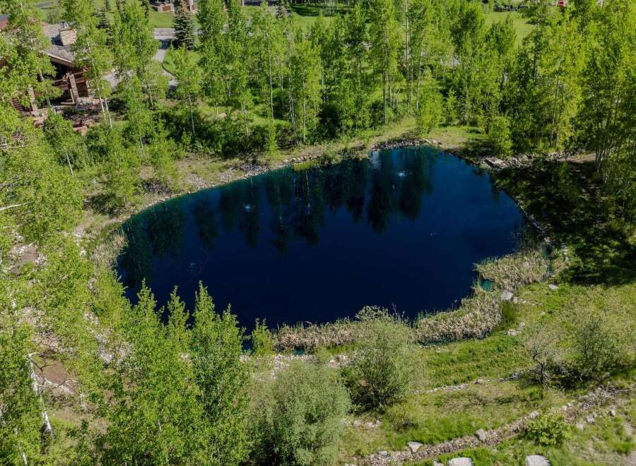 This secluded mountain property boasts a stunning private pond, perfect for enjoying the tranquility of nature.