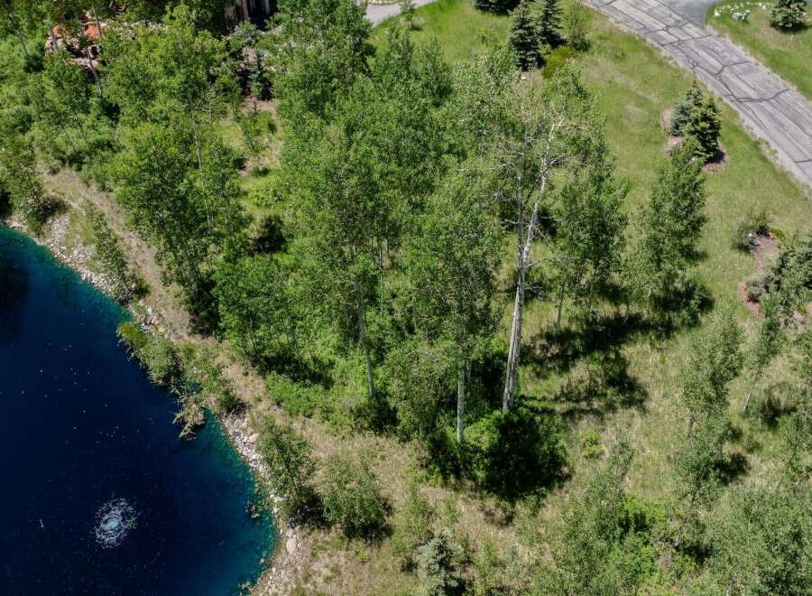 This stunning property boasts a serene, private setting with a picturesque pond and mature aspen trees.