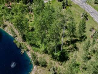 This stunning property boasts a serene, private setting with a picturesque pond and mature aspen trees.