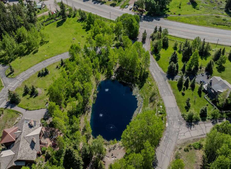 This secluded mountain property boasts a private pond, surrounded by lush greenery and mature trees.