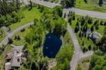 This secluded mountain property boasts a private pond, surrounded by lush greenery and mature trees.