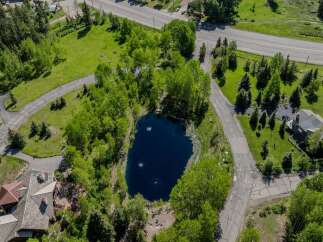 This secluded mountain property boasts a private pond, surrounded by lush greenery and mature trees.