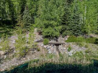 Escape to your own private oasis! This stunning property boasts a serene pond, a charming wooden footbridge, and meticulously landscaped grounds.