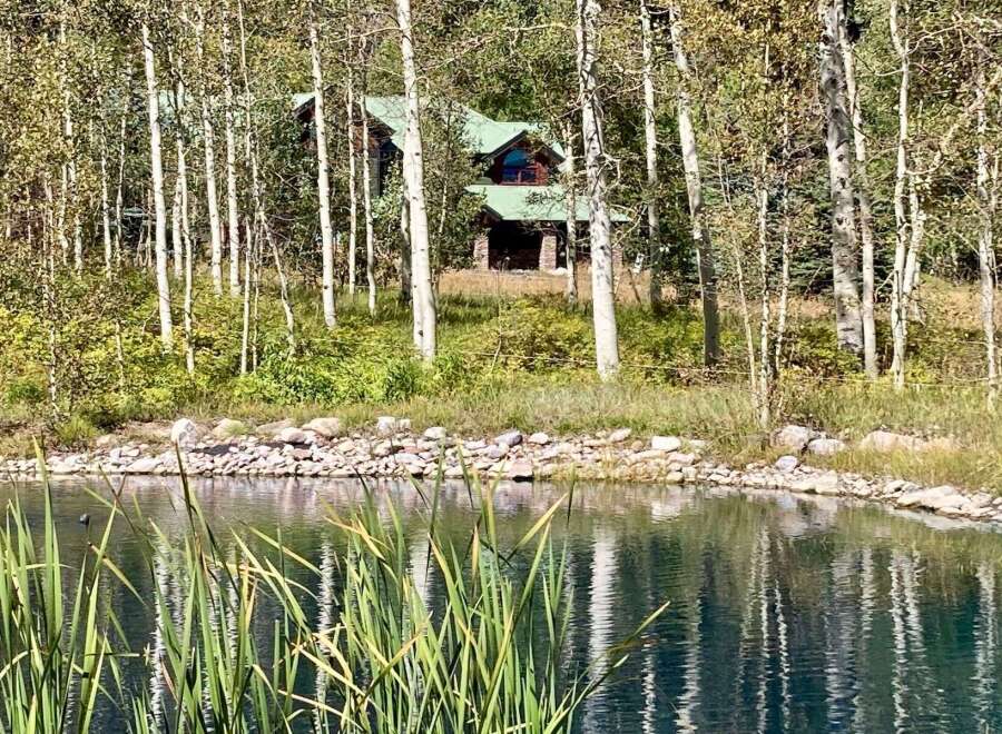 Nestled amidst a serene landscape, this property offers a tranquil retreat with a picturesque pond and lush greenery.