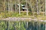 Nestled amidst a serene landscape, this property offers a tranquil retreat with a picturesque pond and lush greenery.