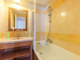 This charming bathroom boasts a bathtub and shower combination, perfect for relaxing after a long day.