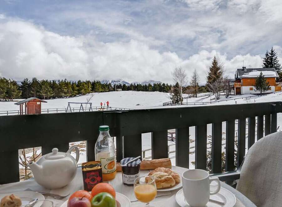 Enjoy a delightful breakfast on your private balcony overlooking breathtaking snowy mountain views.