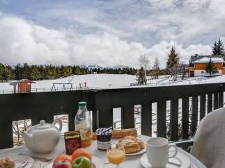 Enjoy a delightful breakfast on your private balcony overlooking breathtaking snowy mountain views.