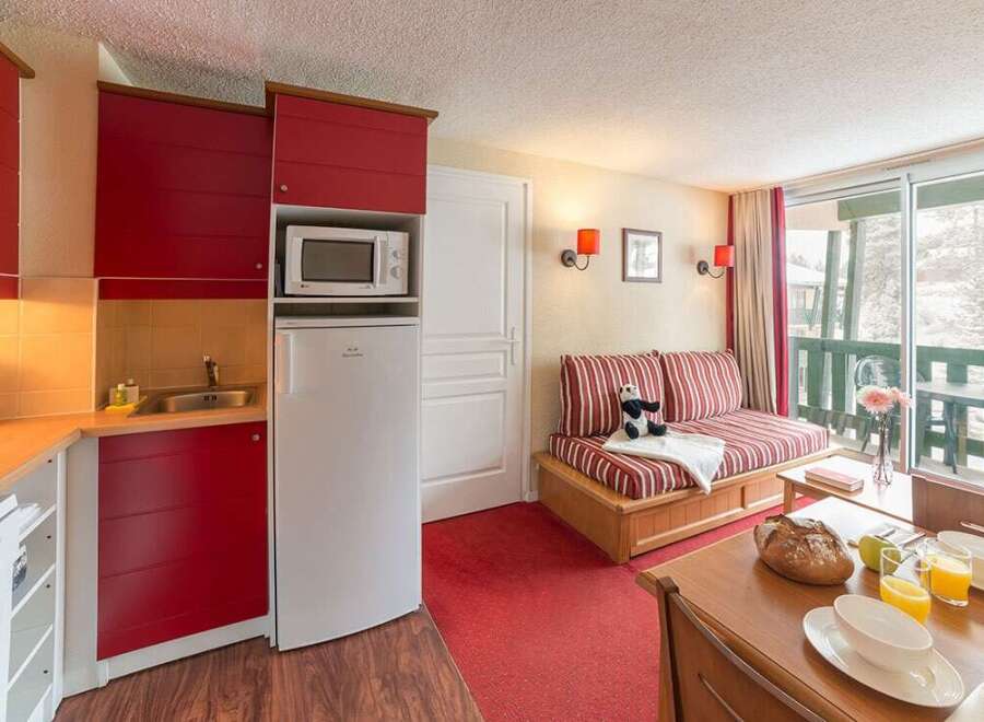 This cozy studio apartment features a fully equipped kitchenette with microwave and refrigerator, perfect for a comfortable stay.