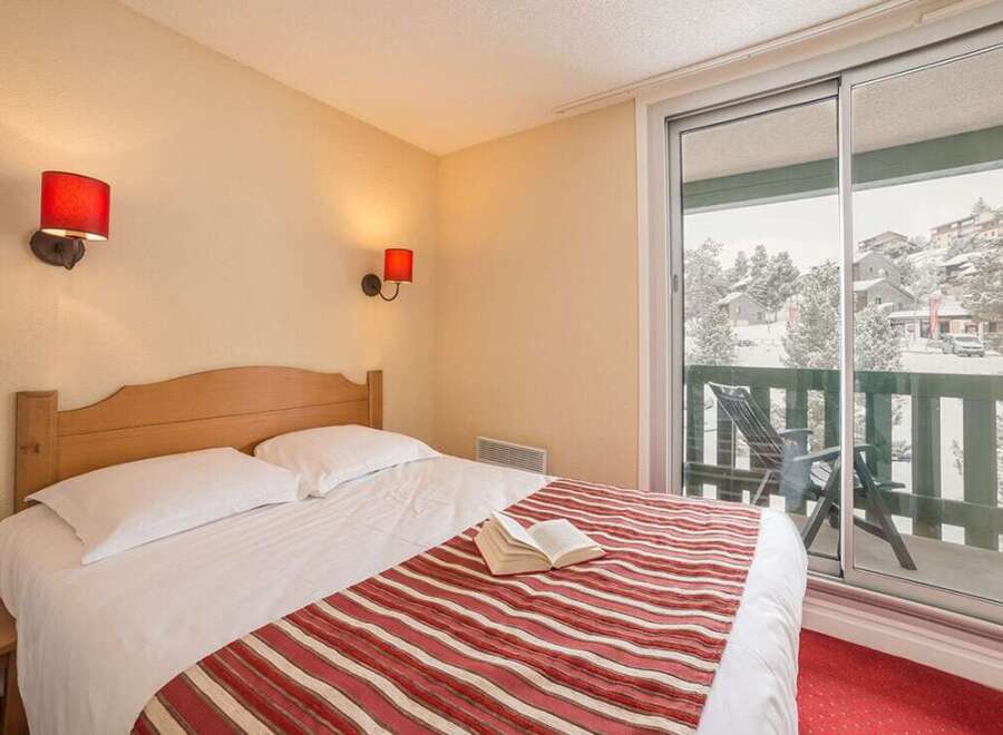 Cozy bedroom with a comfortable double bed and striped bedspread.