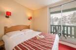 Cozy bedroom with a comfortable double bed and striped bedspread.