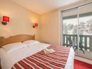 Cozy bedroom with a comfortable double bed and striped bedspread.