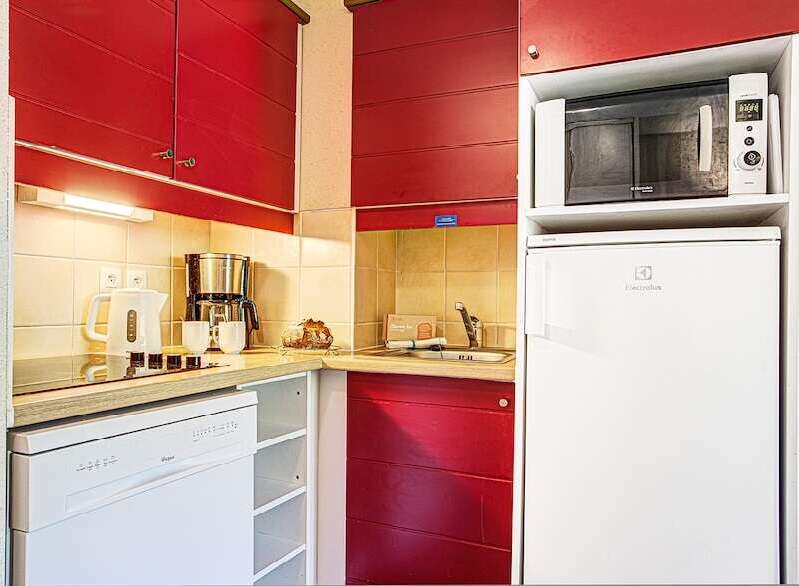 This charming kitchen boasts modern appliances including a dishwasher, microwave, and refrigerator, perfect for a comfortable stay.