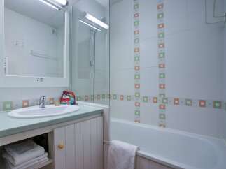 This charming bathroom boasts a clean and modern design, featuring a bathtub, shower, and sink with ample storage space.