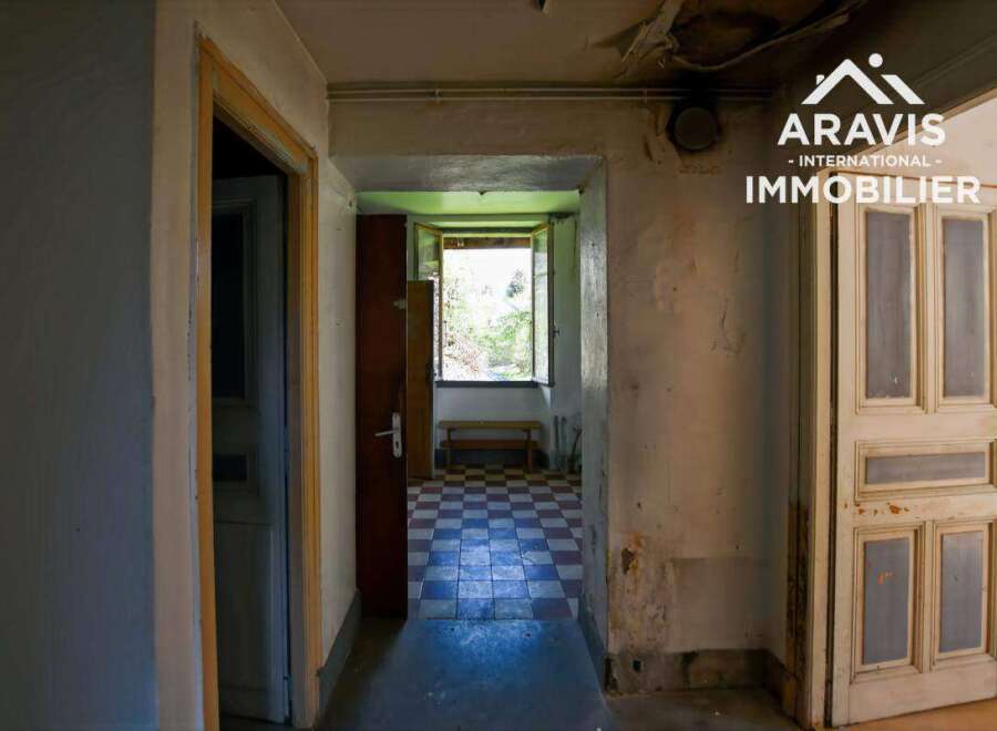 Discover this charming property featuring a hallway with original tiled flooring, leading to a room with a window offering views of nature.