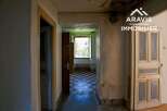 Discover this charming property featuring a hallway with original tiled flooring, leading to a room with a window offering views of nature.