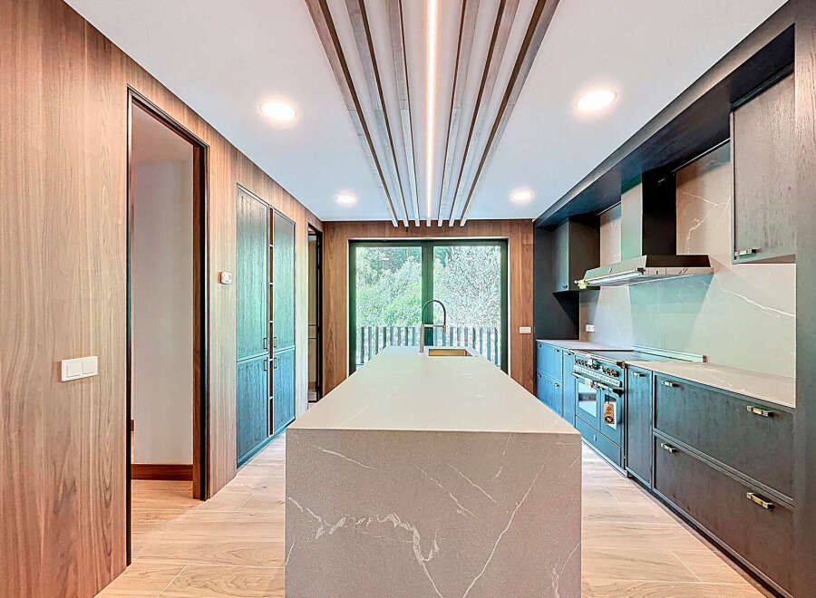 This stunning kitchen boasts a modern design with sleek cabinetry and a spacious island, perfect for culinary enthusiasts.